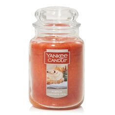 an orange candle with cinnamon rolls in it on a white background and the words yankee candle written