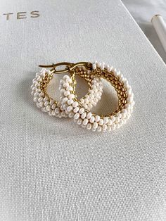 The subtle luster of the ivory pearl beads pairs harmoniously with the warm glow of the gold beads, creating a sophisticated and timeless design. Perfect for both casual and formal wear, these beaded hoop earrings will add a touch of elegance to any outfit.  Earring hoop and closure made with 18K gold plated 304 stainless steel. **Each of my earrings are delicately handwoven bead by bead. I absolutely love making these and want you to know that each piece is made with patience and care from start to finish! These earrings are made with size 11/0 and 15/0 seed beads and Miyuki Japanese Delica beads. I use strong nylon thread to ensure the integrity of each earring.** Handmade Pearl Yellow Gold Hoop Earrings, Handmade Yellow Gold Pearl Hoop Earrings, Handmade Yellow Gold Hoop Earrings With Pearl, White Pearl Charm Hoop Earrings, White Pearl Hoop Earrings With Pearl Charm, Beaded Round Pearl Earrings, Beaded Pearl Hoop Earrings As Gift, Beaded Pearl Hoop Earrings For Gift, Pearl Beaded Hoop Earrings As Gift