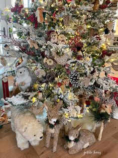 the christmas tree is decorated with animals and pine cones