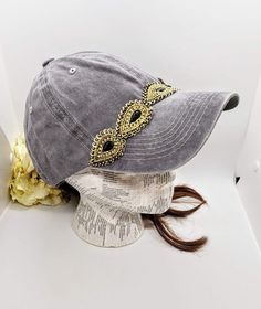 This is a new product from Handmade MKE! This is a distressed gray one size fits all baseball cap with a hole for your ponytail in the back, it is also adjustable. On the front of the hat is band of tear shaped embellishments made with rhinestones and sequins. This is very comfortable, and great to throw on with a plain white T-shirt! Like our Facebook Page and get 10% off when you message me before checkout! Everything made by handmade MKE is one of a kind and unique, however, if you would like Hat Ponytail, Girl Baseball Cap, Ponytail Baseball Cap, Beaded Hat Bands, Plain White T Shirt, Distressed Baseball Cap, Messy Bun Hat, Bun Hat, Beaded Hat