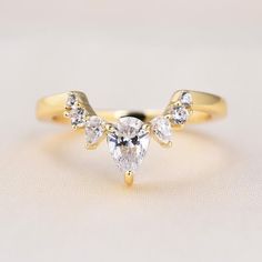 a yellow gold ring with three pear shaped diamonds