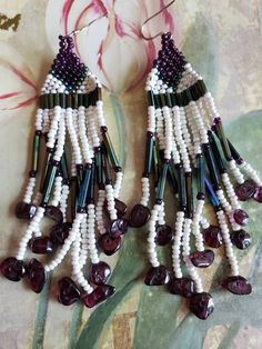 This is a pair of vintage, hand made seed bead earrings. They are made up of white pearle beads, garnet colored beads as well as green/purple iridescent beads and garnets on the bottom. They are hanging, dangling earrings. In addition to seed beads there are long narrow beads as well. They hang from sterling silver French hooks. These earrings measure 4 inches in length, including the French hooks. Don't forget to stop in at my other Etsy shop... http://www.etsy.com/shop/xtdesigns. Follow me on White Beaded Earrings With Round Beads And Bead Caps, White Beaded Earrings With Bead Caps, White Bohemian Earrings With Spacer Beads, Bohemian White Beaded Earrings With Spacer Beads, Beach Boho, Dangling Earrings, Seed Bead Earrings, Bead Earrings, Earrings Sterling Silver