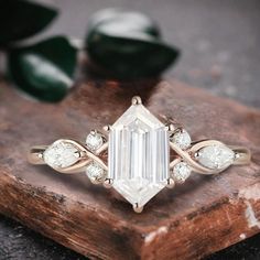 an emerald cut diamond ring on top of a wooden block