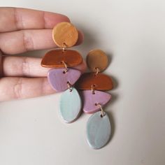 a person is holding some colorful earrings in their hand and it looks like they have been made out of clay