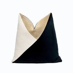 a black, white and gold pillow with two contrasting colors on the front part of it