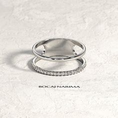 two silver rings with diamonds on them sitting on top of a white surface and the words bocannarma written in black ink