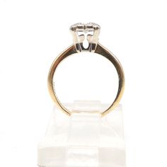 This ultra small ring (it's a size 2.5!) has a Prism Lite diamond prong set in a white gold illusion mount that's supported by a yellow gold band. The diamond is 3.75mm wide and weighs approximately 0.20ct. The illusion mount is designed to visually increase a diamond's perceived size by ensconcing it in white metal, blurring its optical boundaries. HISTORY LESSON: The Prism Lite diamond was a proprietary cut that was first trademarked in 1947. "‘Prism-Lite’ diamonds were in demand for their spe Yellow Gold Platinum Diamond Ring With Single Diamond, Vintage Diamond Ring With Tension Setting, Platinum Solitaire Ring In Yellow Gold, Vintage Round Cut Diamond Ring With Tension Setting, Classic White Diamond Ring With Tension Setting, White Marquise Cut Diamond Ring, Classic White Ring With Single Diamond, Classic Emerald Cut Diamond Ring With Tension Setting, Classic Marquise Cut Ring With Prong Setting