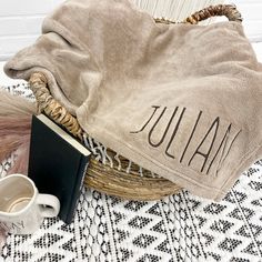 the personalized hat is next to an open book and a cup on a table