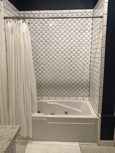 a white bath tub sitting next to a shower