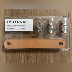 an assortment of screws and nuts in a package on a wooden table with a label stating osternas