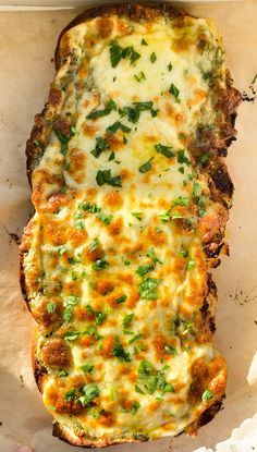 a cheesy bread dish with cheese and herbs on the top, in a pan