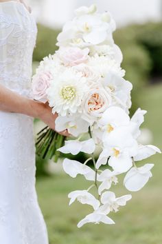 a bride holding a bouquet of white and pink flowers