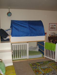 there is a bunk bed with a blue cover over it and a green rug on the floor