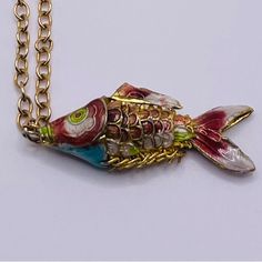 a gold chain with a colorful fish on it