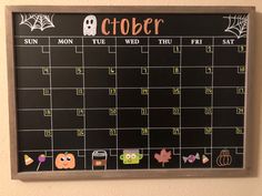 a chalkboard calendar with stickers on it in the shape of a pumpkin and ghost