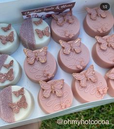 a box filled with lots of pink and white cupcakes