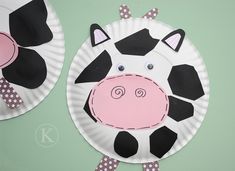 two paper plates decorated to look like cows with polka dots on them, one is pink and the other is black