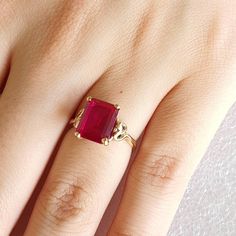 Gold and simulated red Ruby ring.   Ring is made with 9 carat yellow gold.  Simulated red Ruby is Emerald cut and measures 10mmsx8mms. Ring size is L (Australian size) or 5 1/2 (US size). Ring is ready to ship in 1-2 working days.  We resize free of charge.  Please allow a couple of additional days for resizing. This ring can be custom made to your specification.  Contact us with your queries. All my rings come in a velvet ring box. Classic Ring With Prong-set Lab-created Ruby, Classic Ruby Ring With Diamond Cut, Classic Ruby Solitaire Rings, Classic Lab-created Ruby Ring With Diamond Cut, Formal Birthstone Ring With Lab-created Ruby, Classic Lab-created Ruby Rings For Promise, Formal Lab-created Ruby Ring With Diamond Cut, Classic Promise Ring With Lab-created Ruby, Emerald Cut Ruby Ring In Gold