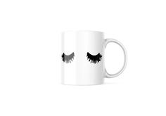 a white coffee mug with black eyelashes on it