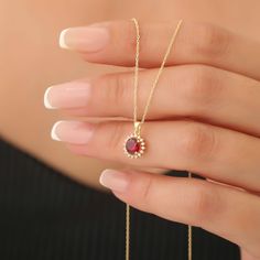 Indulge in the luxurious charm of our Round Ruby Necklace, beautifully handcrafted from 14K solid gold and surrounded by an exquisite ring of real diamonds. This stunning piece features a vibrant, deep red ruby - the birthstone for July - known for its striking color that symbolizes passion and vitality. The captivating contrast of the ruby and shimmering diamonds creates a timeless design that is perfect for special occasions or everyday elegance.  Each necklace is meticulously made by skilled artisans, ensuring that every detail is flawlessly executed. The combination of solid gold and sparkling diamonds not only elevates the overall aesthetic but also guarantees durability and timelessness, so you can cherish this piece for years to come. The secure clasp ensures a comfortable fit, allo Everyday Elegance, Solid Gold Necklace, Ruby Necklace, July Birthstone, Red Ruby, Sparkle Diamonds, Real Diamonds, Deep Red, Timeless Design