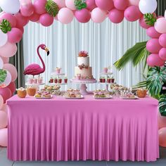 a pink table topped with a cake and lots of desserts next to a flamingo balloon