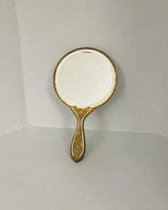 a white and gold plate with a mirror on the wall in front of it,