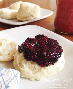 a white plate topped with food on top of a wooden table next to a jar of jam