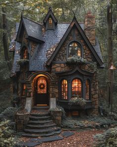 a small stone house in the woods with steps leading up to it's entrance