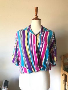 "Such a versatile piece for all genders!  Marked as size medium  Tag says \"Everblue from Triple 5\"" Summer Blouse With Vertical Stripes And Relaxed Fit, Retro Multicolor Short Sleeve Shirt For Spring, Fitted Rainbow Short Sleeve Tops, Blue Vertical Stripes Short Sleeve Top, Trendy Short Sleeve Tops With Vertical Stripes, Colorful Short Sleeve Casual Blouse, Colorful Casual Short Sleeve Blouse, Rainbow Cotton Shirt For Summer, Summer Vertical Stripes Button-up Blouse