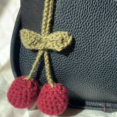 two crocheted cherries attached to a purse