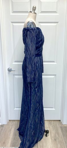 Although discontinued from the Basix Black Label line, this dress is perfect for someone looking for coverage but a little sexiness with the cold shoulder look. This fit and flare features all-over lace under the embroidered pattern with a matching satin belt to bring in the waist. Color: Navy/Nude. Please note: This listing is for our sample dress only. This dress has been tried on in our Newtown, CT shop but has never been worn to an event or altered in any way. MeasurementsBust: 40"Waist: 32" Luxury Lace Evening Dress With Fitted Bodice, Elegant Floor-length Lace Dress For Night Out, Silk Evening Dress With Lace Sleeves, Off-shoulder Lace Party Gown, Off-shoulder Lace Evening Gown, Fitted Lace Dress With Belt, Fitted Lace Belted Dress, Lace Belted Dress For Party, Fitted Belted Dress For Gala