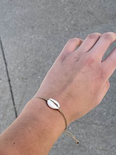 a person's hand with a bracelet on it that has a coin attached to it