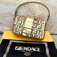 Gorgeous Authentic Fendi X Versace Fendace Logo Gold Metallic Top Handle Brooch Mini Bag. Featuring An Exterior Gold Color, Ff Logo Brown Leather Interior, Perforated Ff Logo Throughout With A Top Handle. Gold Hardware Color. Excellent Condition. Includes Dust Bag Only. No Box. Measures Approx 8”X4.5”X1.5”. Luxury Rectangular Shoulder Bag With Gold-tone Logo Plaque, Designer Rectangular Shoulder Bag With Metal Logo, Luxury Gold Bags With Branded Hardware, Rectangular Gold Bag With Logo Hardware, Gold Rectangular Bag With Logo Hardware, Luxury Rectangular Shoulder Bag With Metal Logo, Luxury Baguette Shoulder Bag With Detachable Strap, Luxury Shoulder Baguette Bag With Gold-tone Hardware, Designer Evening Bag With Metal Logo