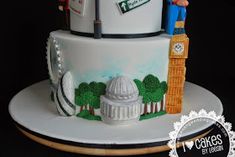 a three tiered cake decorated with an image of london and england on it's side