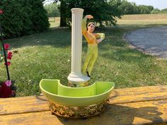 a statue of a man holding a frisbee on top of a wooden table