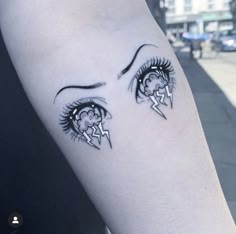 a woman's arm with black and white tattoos on her face, the eye has lightning bolts coming out of it