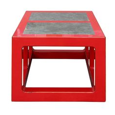 a red coffee table with grey top on white background