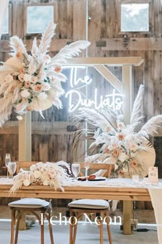 an image of a table setting with flowers and feathers on the tables in front of it