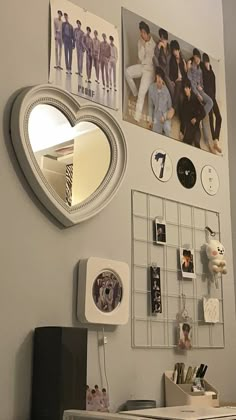 a white desk topped with a laptop computer next to a heart shaped mirror