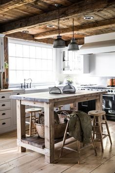 a kitchen with an island made out of wood and two stools in front of it