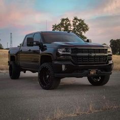 a black truck parked on the side of a road