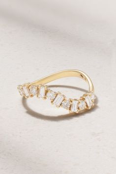 a yellow gold ring with three baguette cut diamonds on the top and bottom