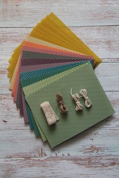 four pairs of earrings sitting on top of different colored fabric swatches in front of each other