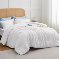 a bed with white sheets and pillows in a room