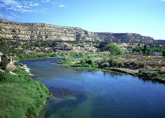 a river running through a lush green hillside