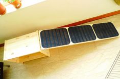 a solar powered device sitting on top of a wooden bench next to a window and potted plant