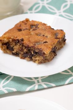 a piece of chocolate chip cookie sitting on top of a white plate