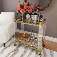 a gold bar cart with drinks and flowers on it