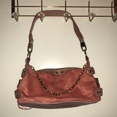 Handbag Is Faux Leather, Has Studs, A Decorative Gold Chain. Used A Couple Of Times But In Good Condition Zipper Is Stiff Does Not Move Easy Has Not Been Used Much,Has A Mini Coin Bag Connected To It. Inside Of Lineing Of Bag It Has A Stain Where Zipper Compartment Is Located. Shoulder Bag With Branded Hardware, Shopping Satchel Baguette Bag With Branded Hardware, Shopping Leather Baguette Bag With Branded Hardware, Leather Baguette Bag With Branded Hardware For Shopping, Leather Baguette Bag With Branded Hardware And Double Handle, Pink Leather Bag With Metal Hardware, Pink Shoulder Bag With Metal Hardware For Shopping, Top Handle Shoulder Bag With Metal Hardware For Errands, Pink Shoulder Bag With Metal Hardware