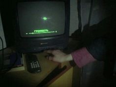 a person is playing an old school video game on the television set in the dark